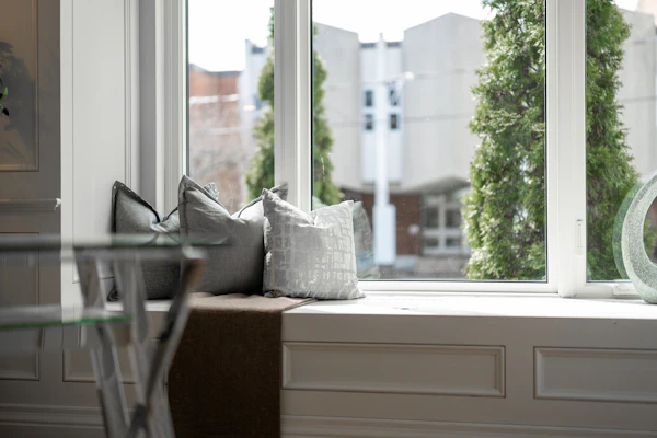 Example photo: a window seat with cushions beneath a large window